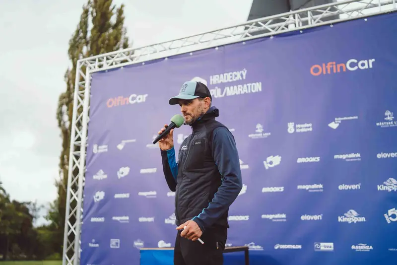 Moderátor na pódiu s mikrofonem na sportovní akci