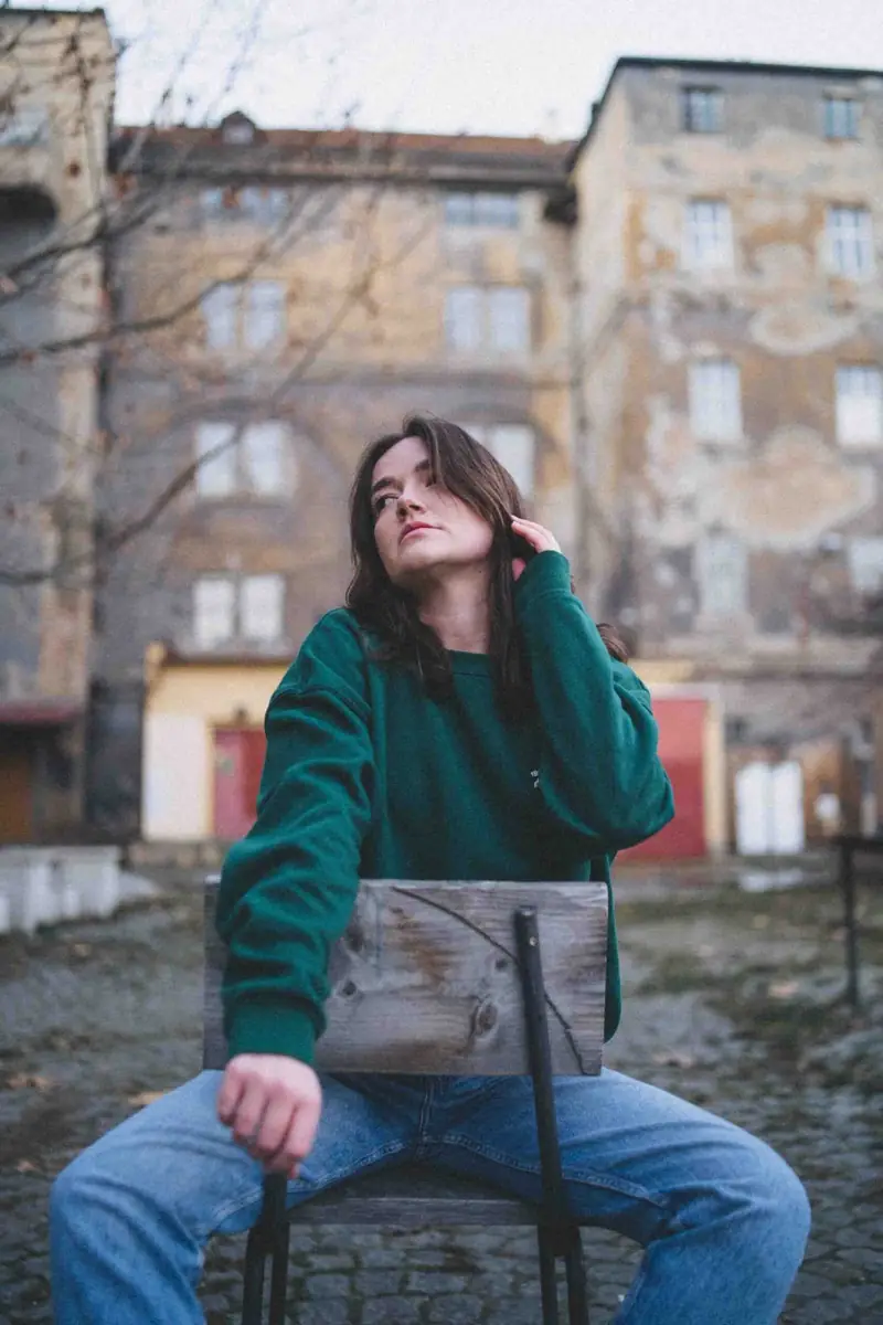 Mladá žena sedí na židli ve městě