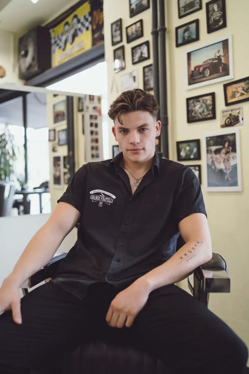 Portrét mladého muže sedícího v barbershopu