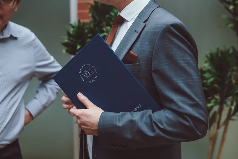 Detail muže v obleku se složkou dokumentů