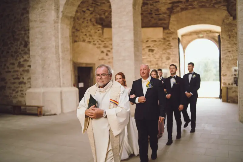 Oddávající a svatební průvod v kamenné síni