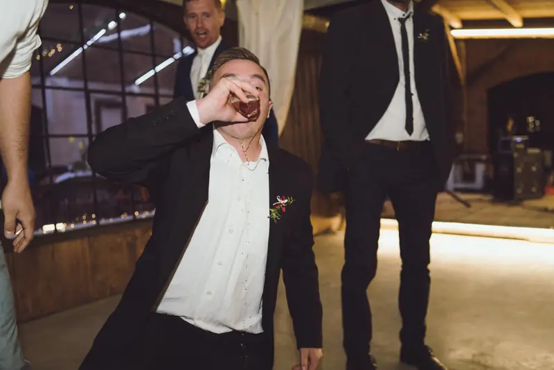 Svatební host pije panáka při oslavě