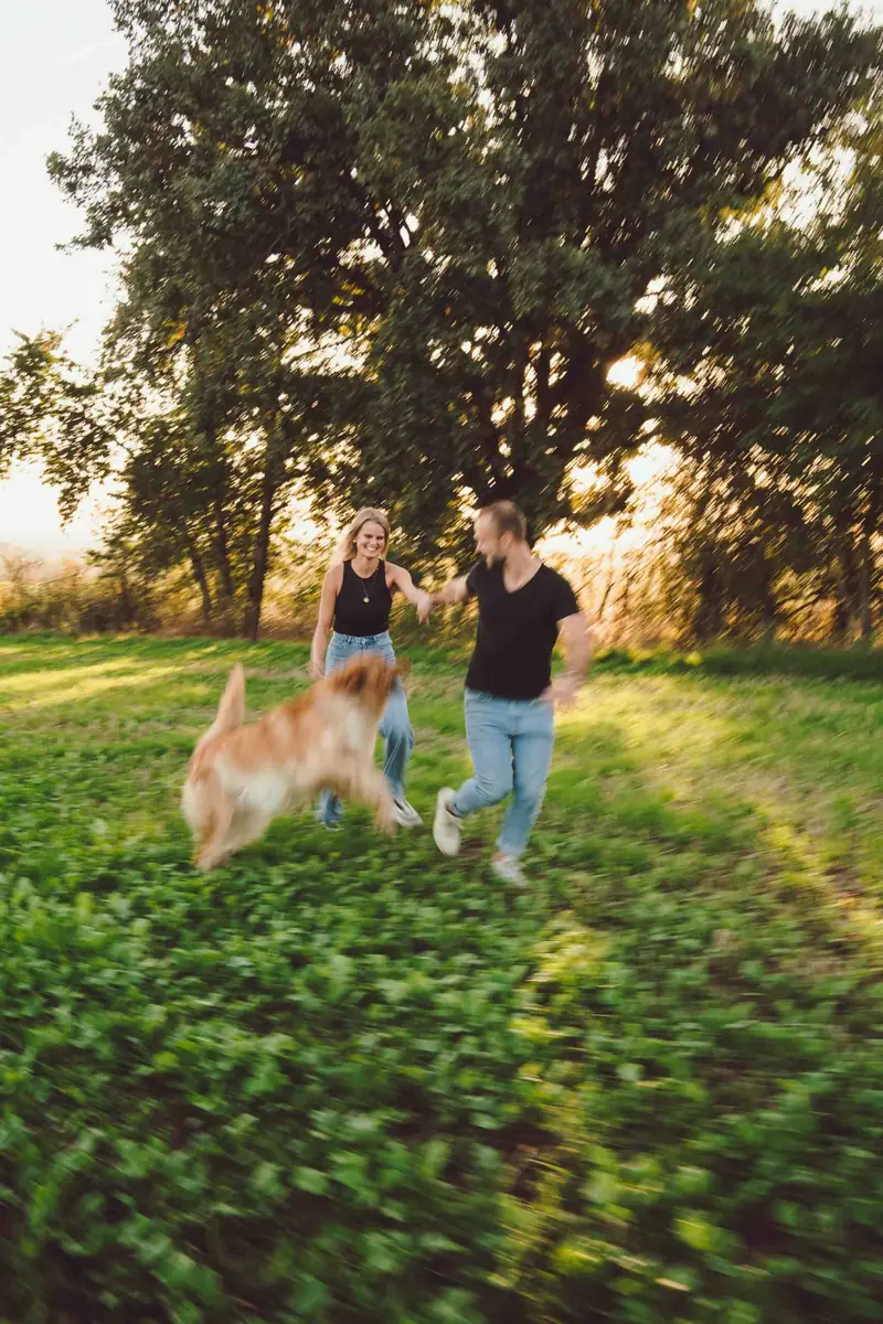 Pár si hraje se psem na louce