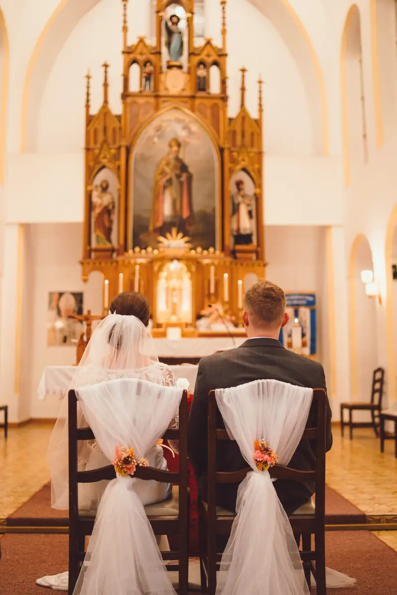 Novomanželé před oltářem v kostele