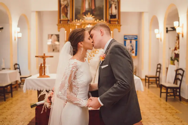 Polibek novomanželů před oltářem v kapli