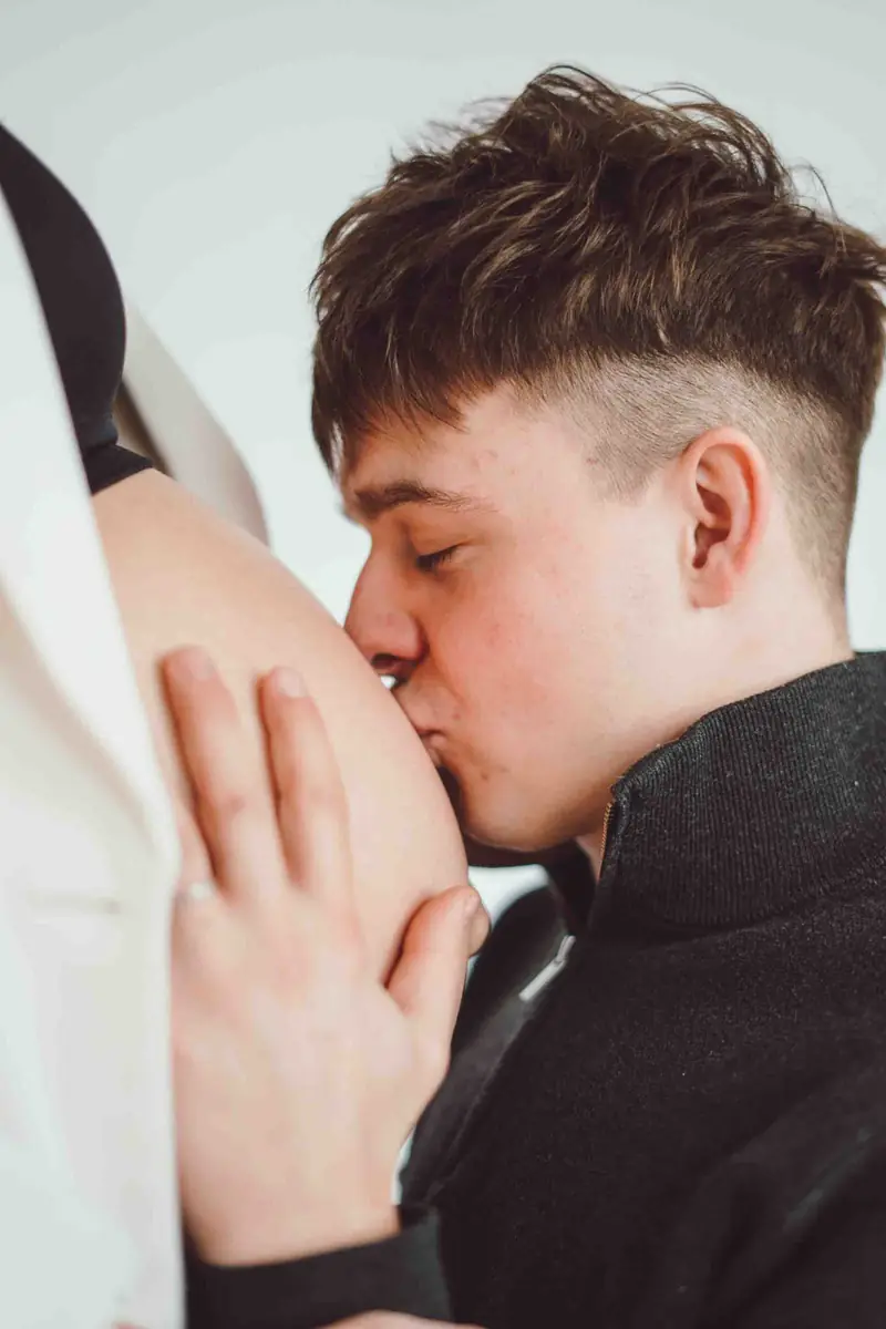 Partner líbá těhotenské bříško