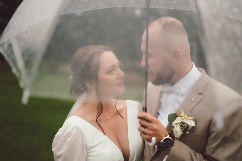 Nevěsta a ženich pod průhledným deštníkem