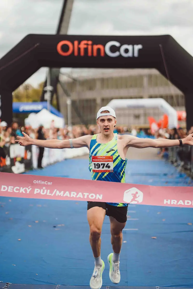 Běžec probíhá cílovou páskou půlmaratonu