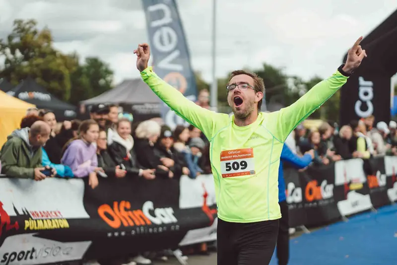 Běžec v cíli Hradeckého půlmaratonu se zdviženýma rukama