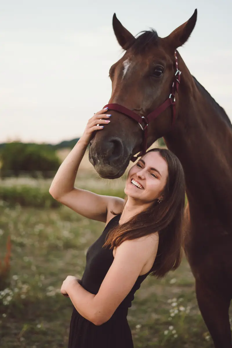 Usměvavá žena hladí koně po hlavě