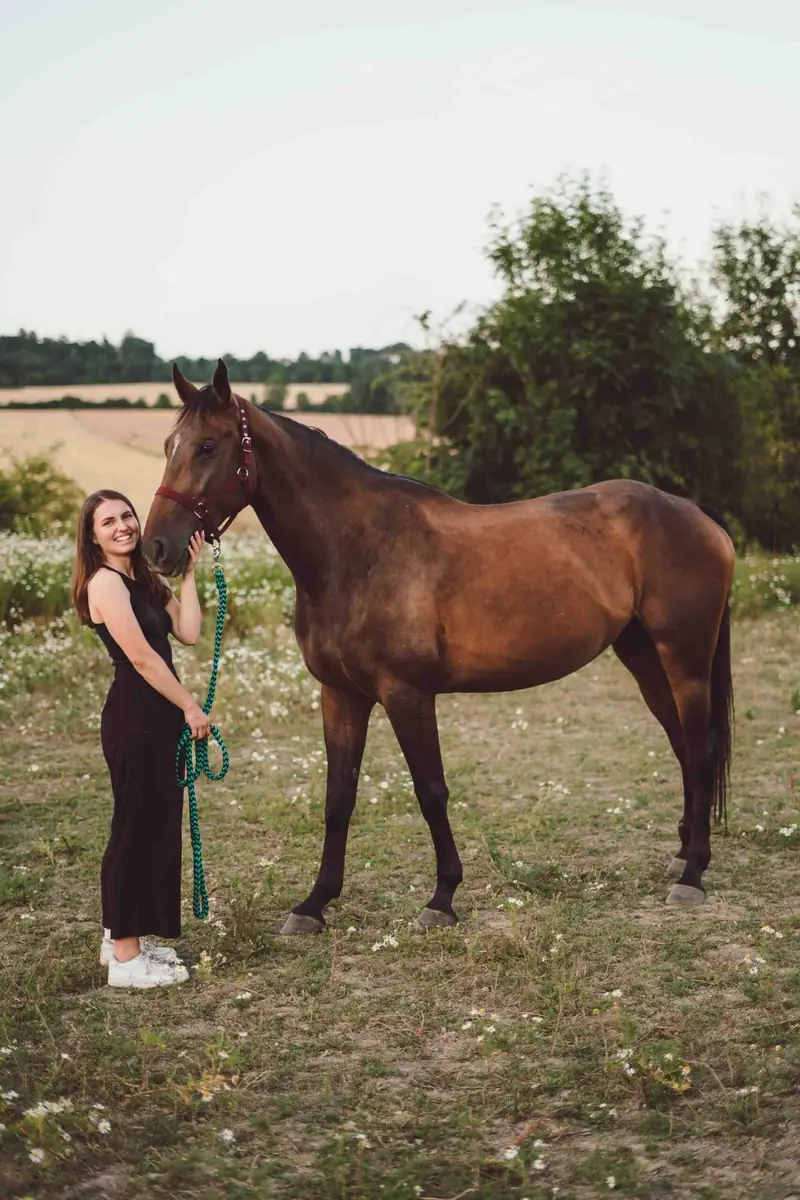 Žena s koněm na pastvině