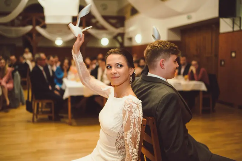 Nevěsta mává ubrouskem během svatební hostiny