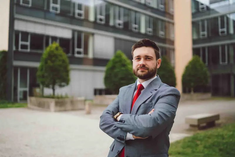 Firemní portrét muže v obleku před kancelářskou budovou