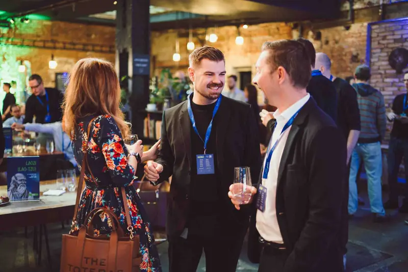 Hosté konference si povídají se sklenkou v ruce